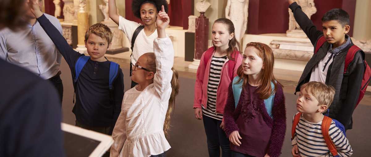 Pupils and teacher on a school field trip to a museum, with a guide.