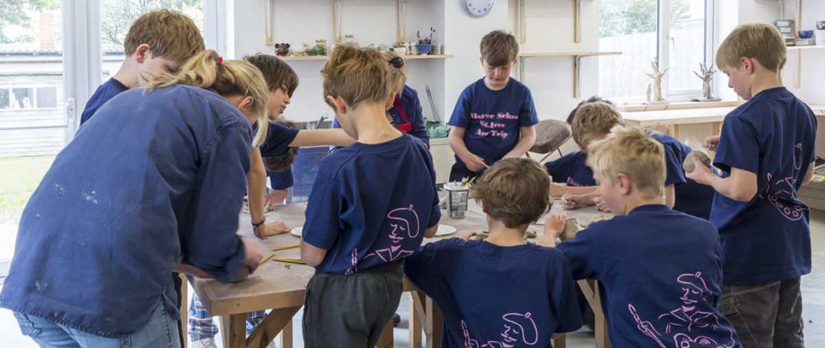 Children working standing up at tables in the Clore Learning Studio at the Leach Pottery, St Ives, Cornwall. Photo Matthew Tyas